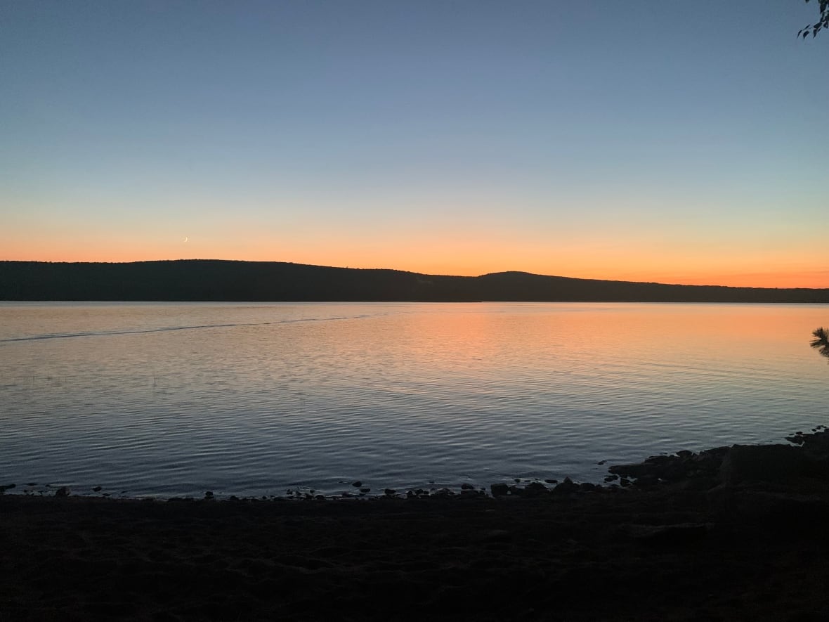 A pale orange sunset over a body of water