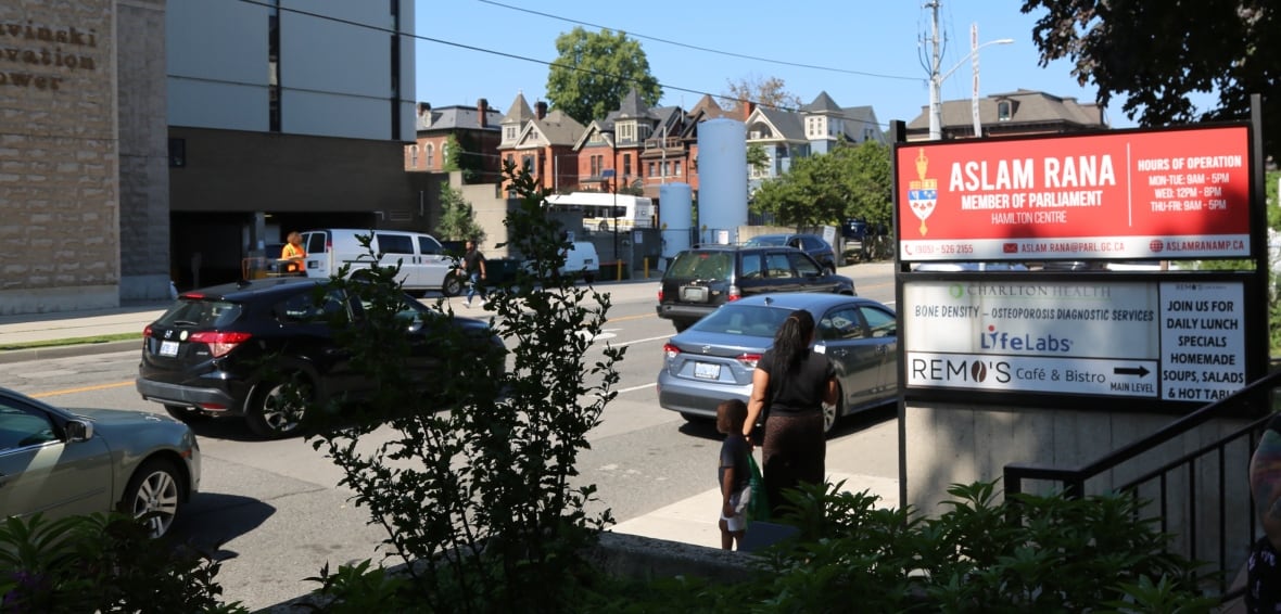 A streetscape photo that includes a sign for an MP's office