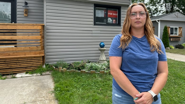 A woman standing outside a home.