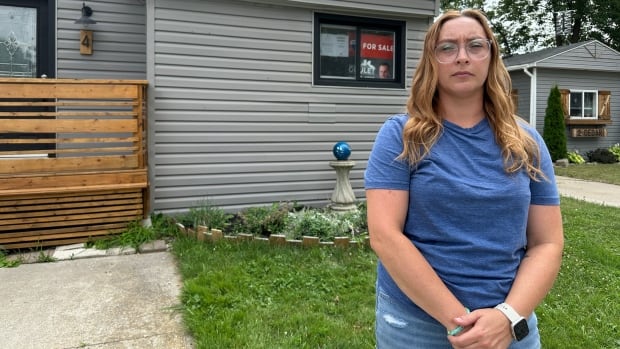 A woman standing outside a home.