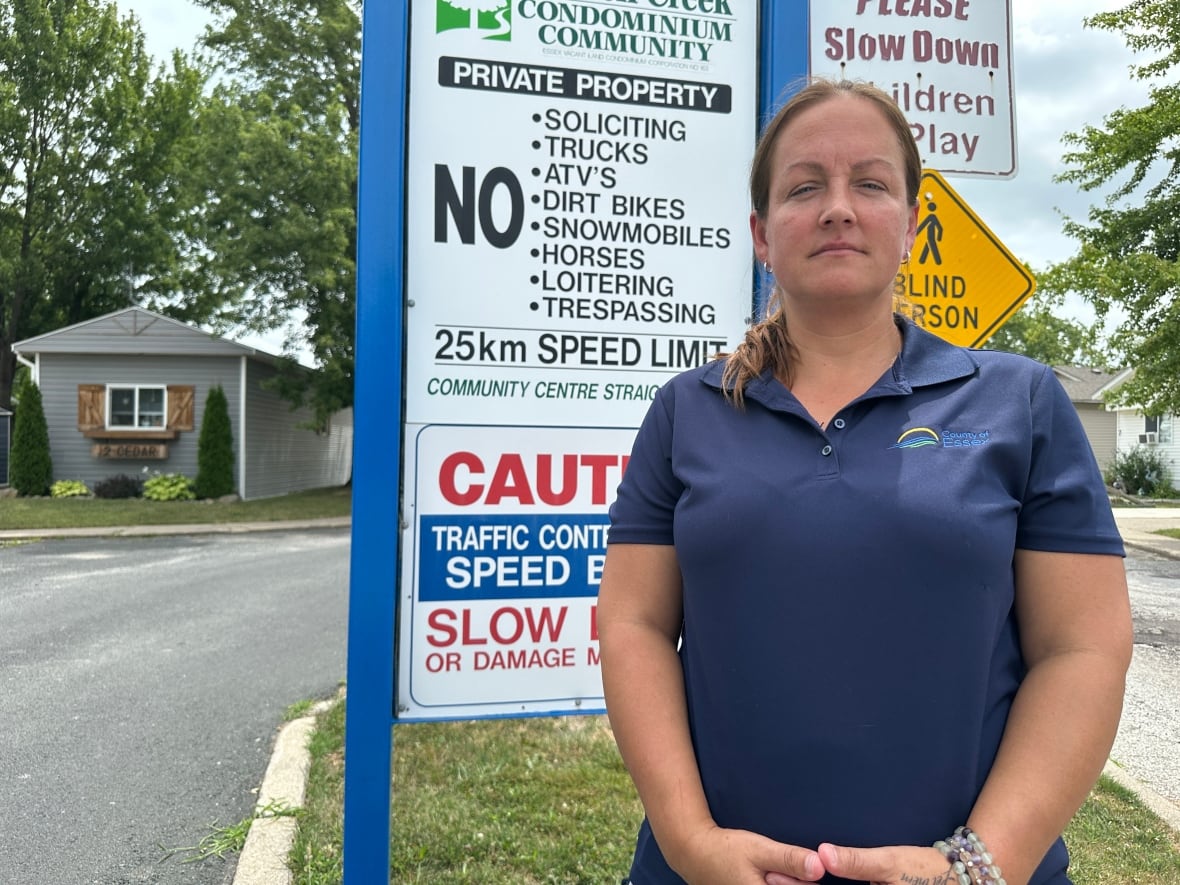 A woman standing in front of a sign.