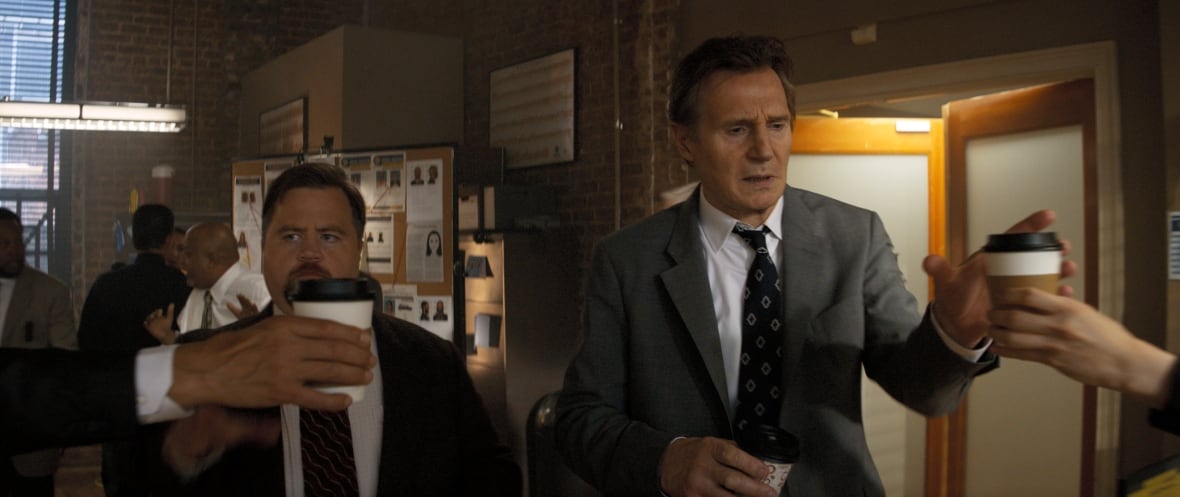 Two men in suits reach for coffee cups held by off-screen hands.