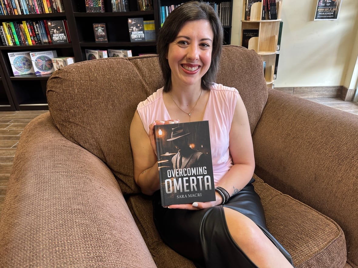A woman holds up a book in a bookstore.