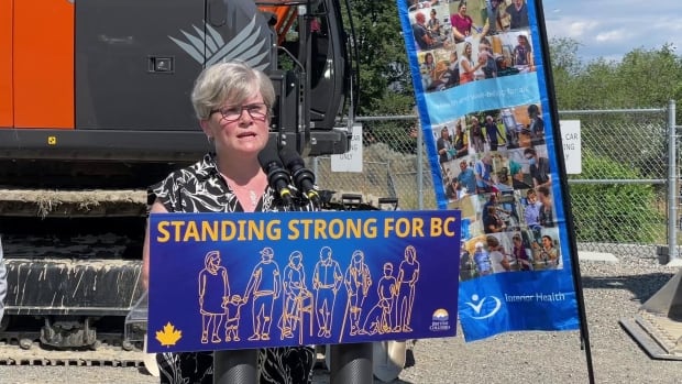 Health Minister Josie Osborne speaking while at a podium. She is a woman with short white hair.