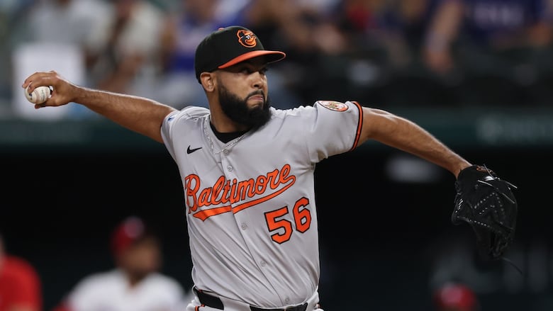 A men's baseball pitcher delivers a pitch.