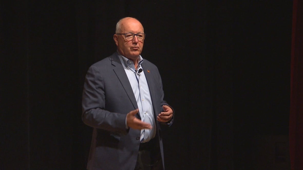 A man gesticulating on a stage.