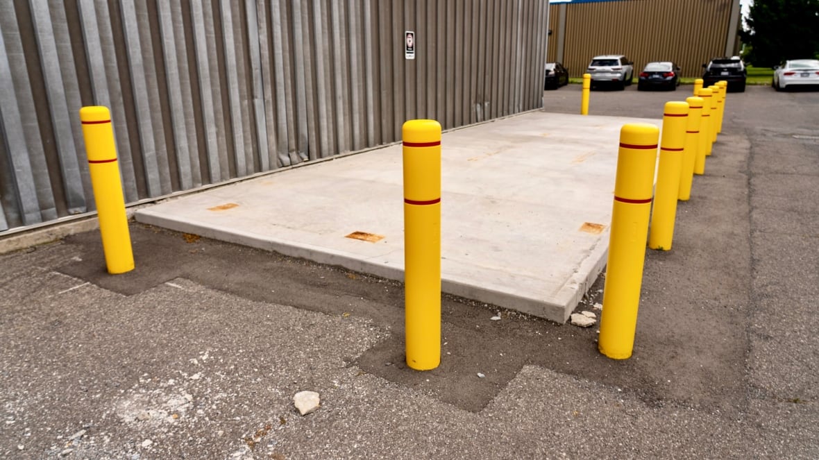 A concrete slab with yellow poles around it