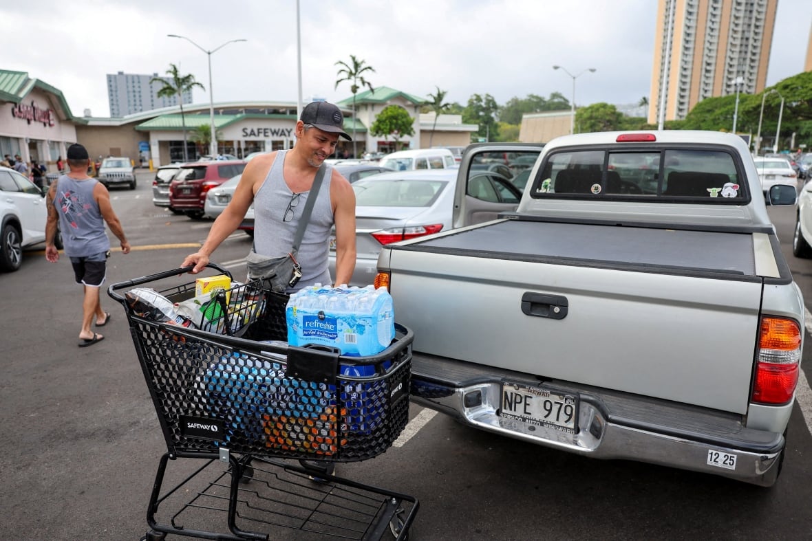 A man unloads water and supplies into a truck.