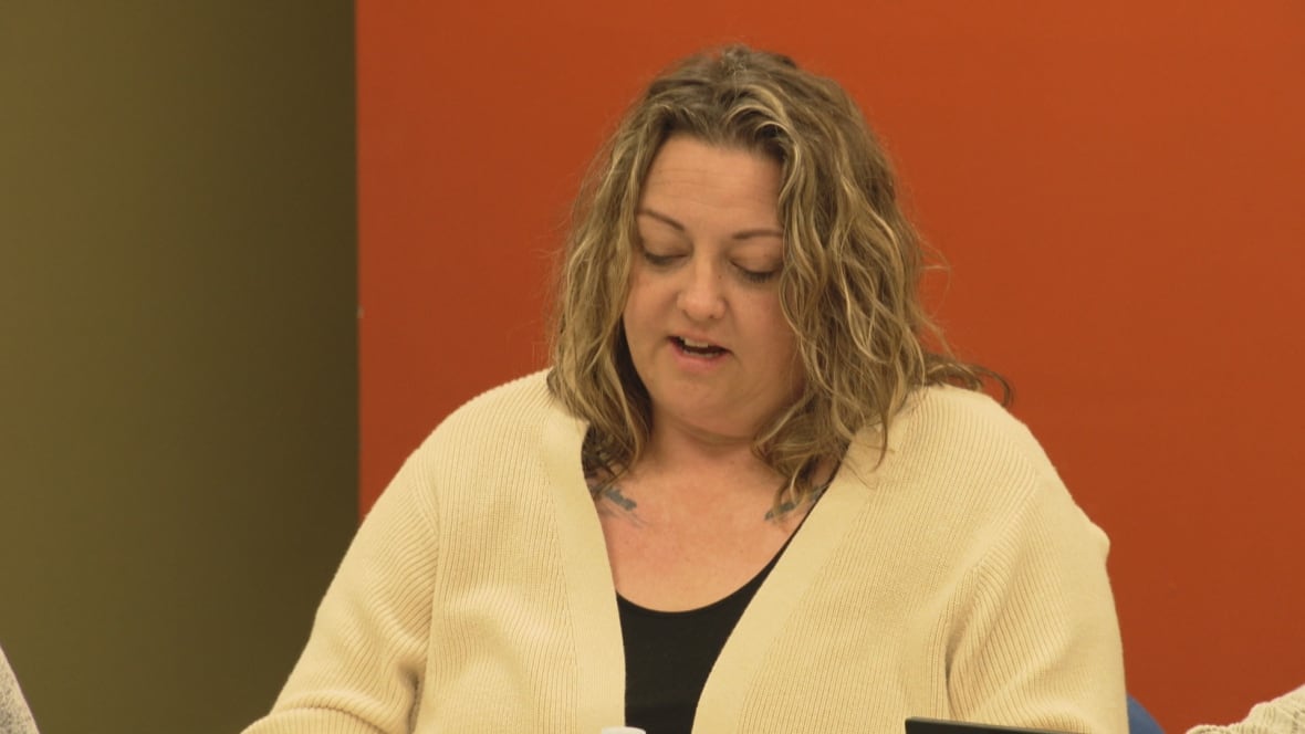 A woman reading from a piece of paper