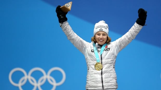 A woman celebrates on a podium.