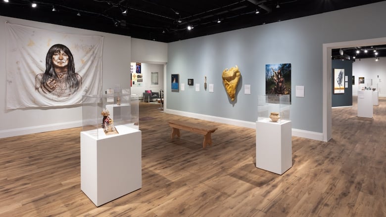 Wider shot of museum gallery and the other pieces included in exhibition include Buffy Sainte-Marie portrait.