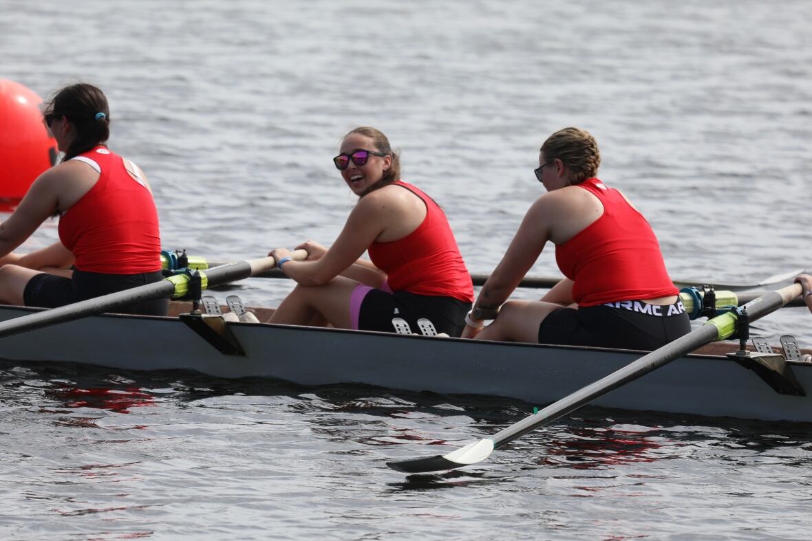 Cierre a un grupo de mujeres con camisas rojas en un bote de hileras.