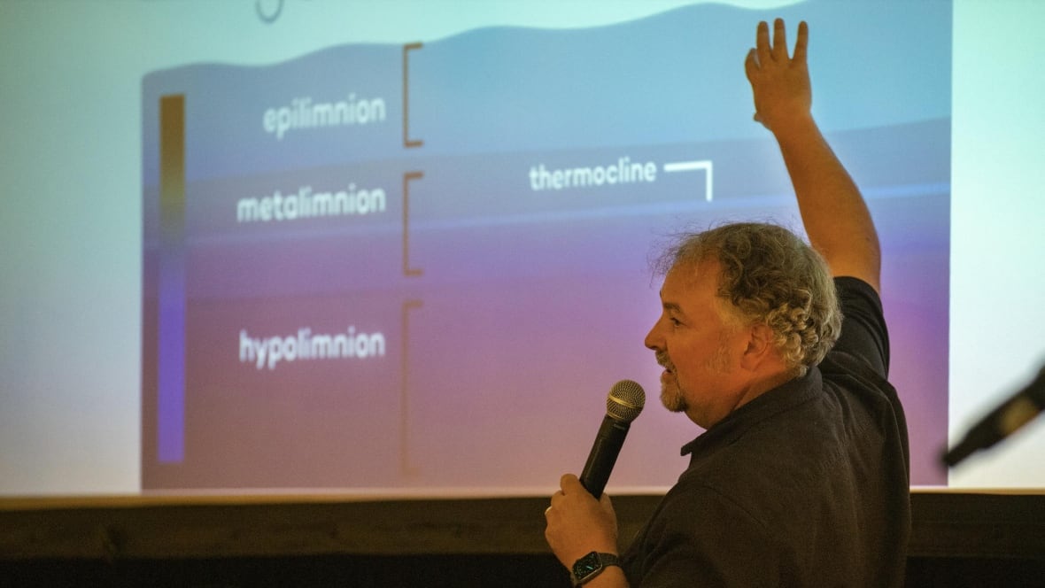 A man points at a powerpoint presentation.