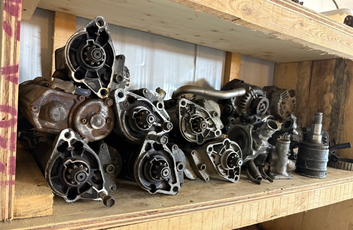 Las piezas de metal del automóvil se encuentran en un estante de madera.
