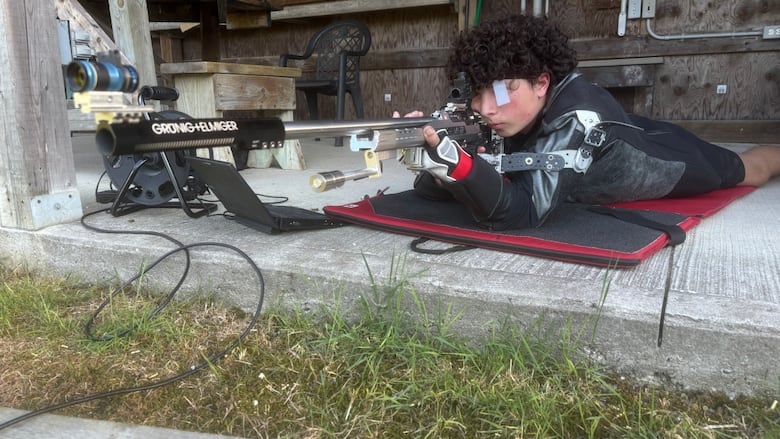 Lucas laying down with his gun aimed.