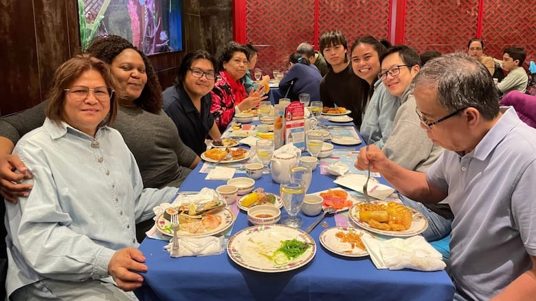 A group of people seated around a restaurant table. 