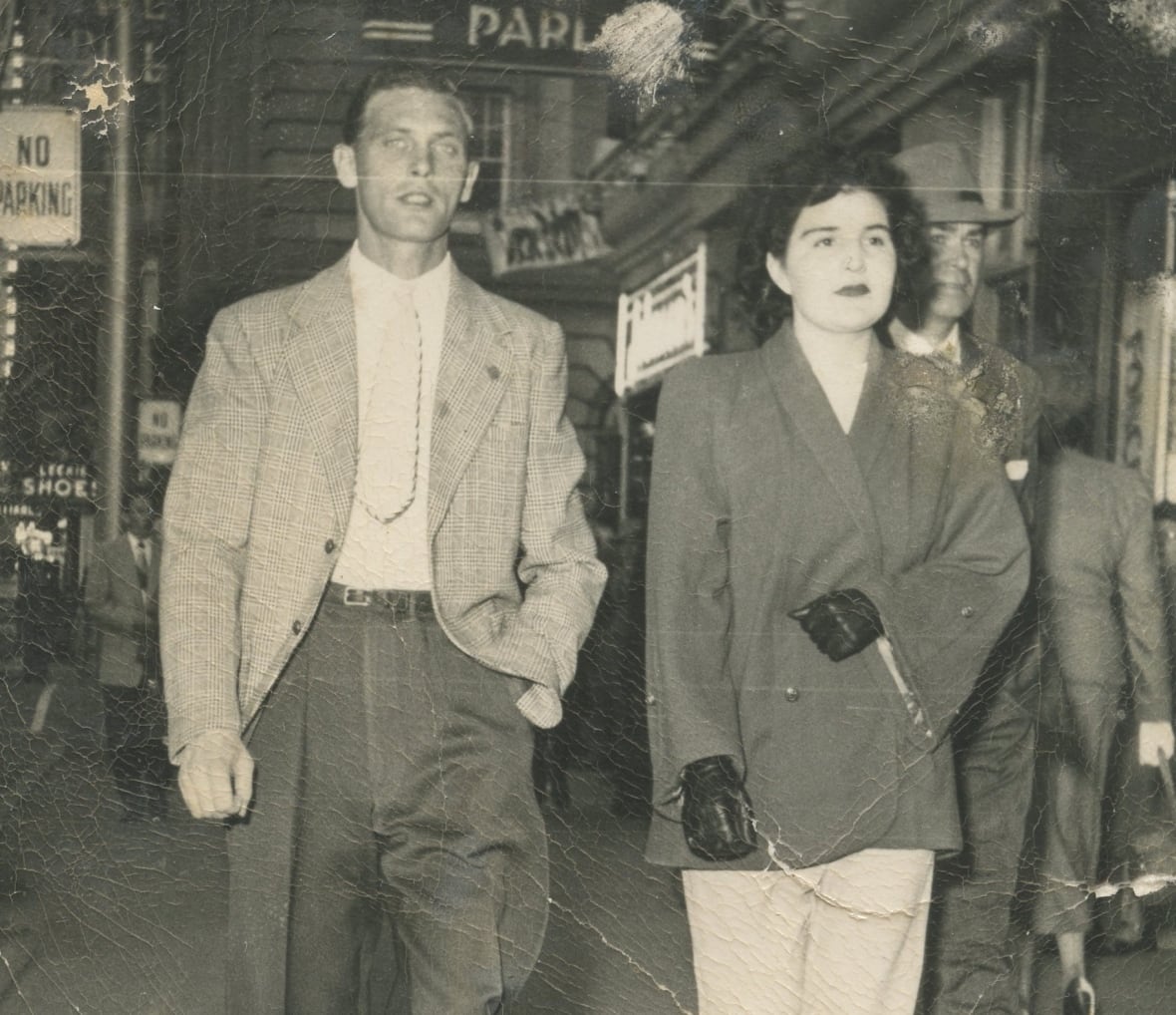 A man and woman walking on a city street