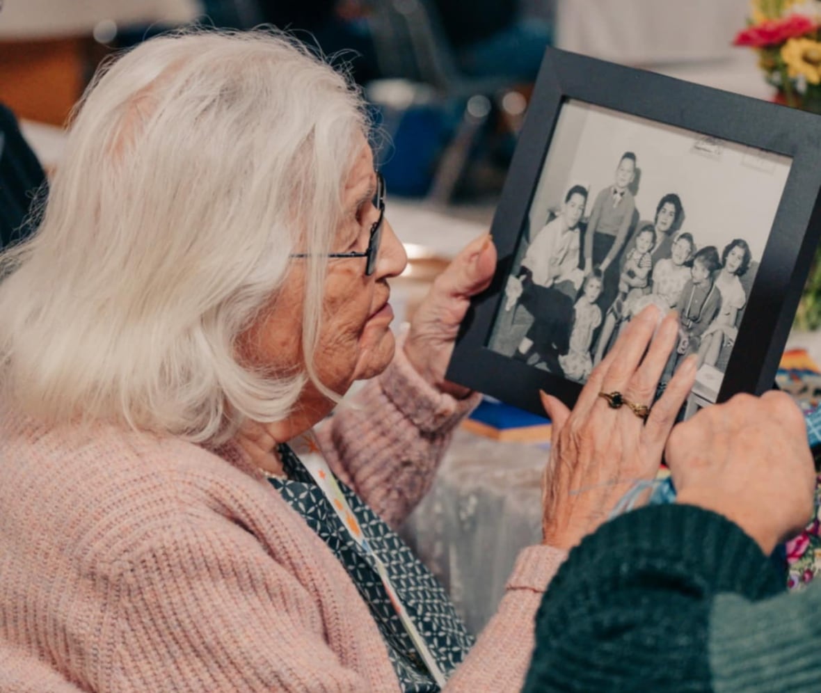 A woman touches a photo of her children