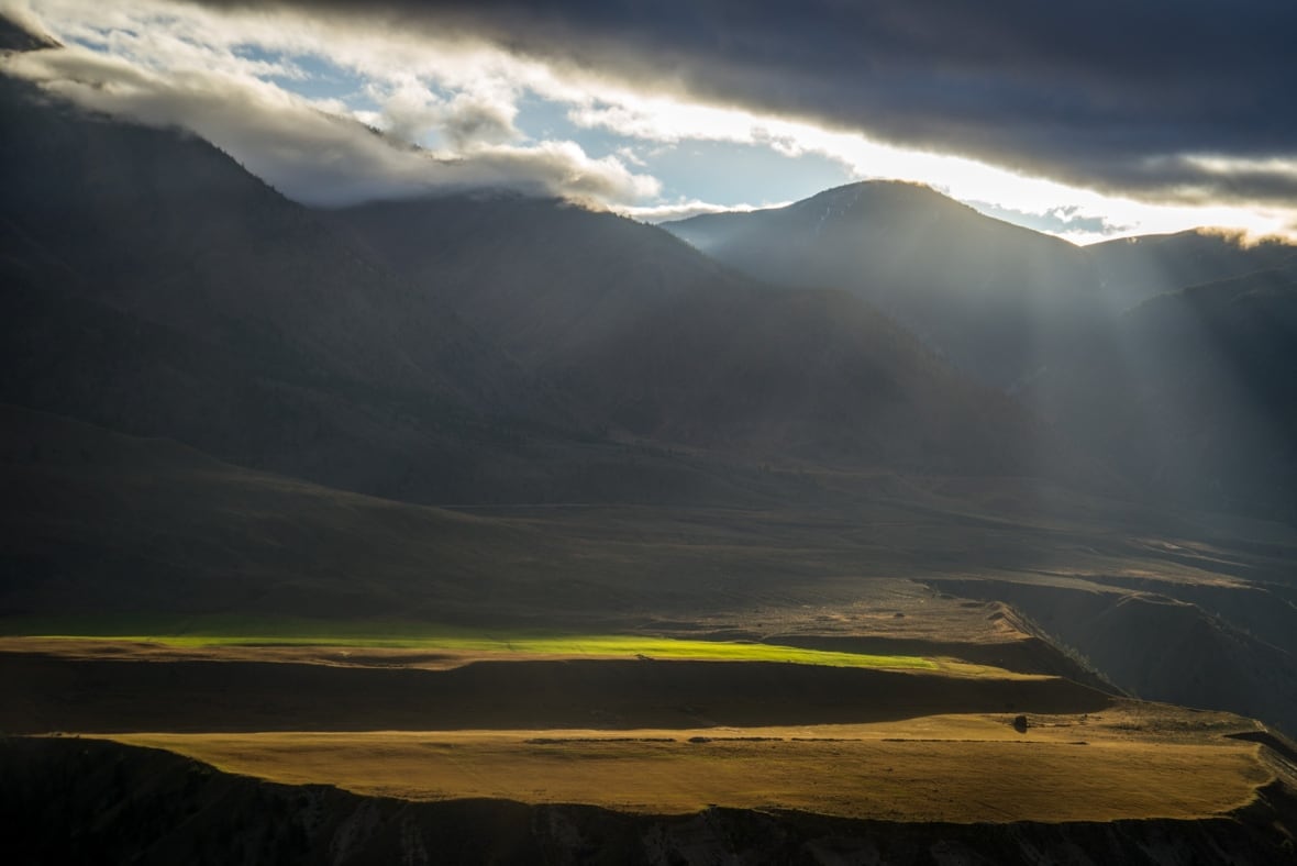 A mountain valley with dramatic golden hour lighting.