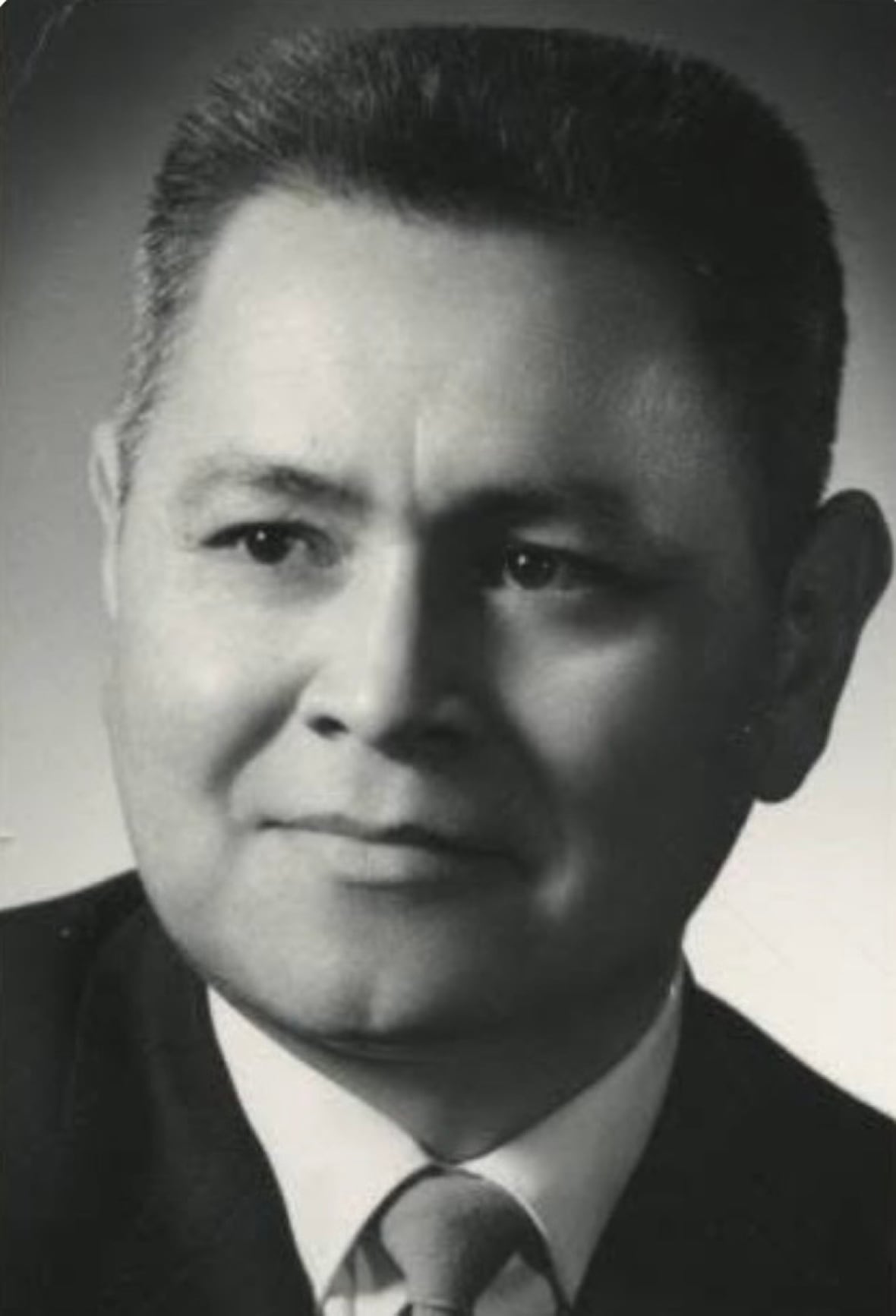 A headshot of a man wearing a suit. 