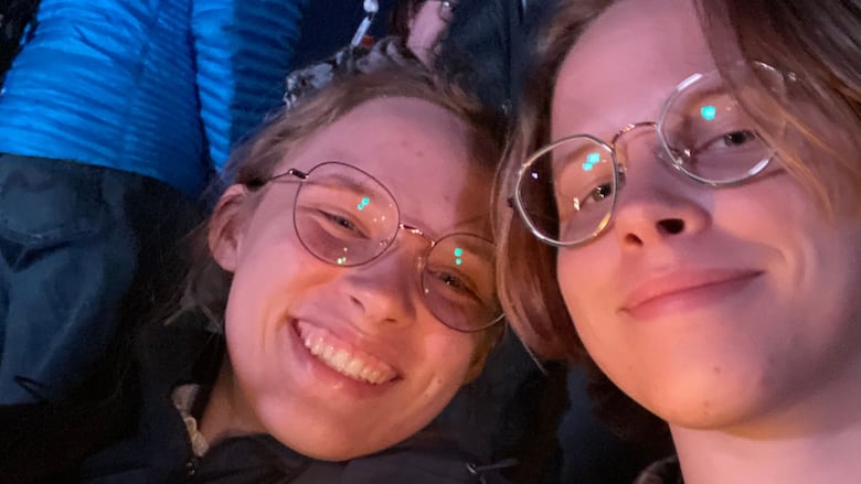A smiling man and woman pose for a selfie while holding a candle.