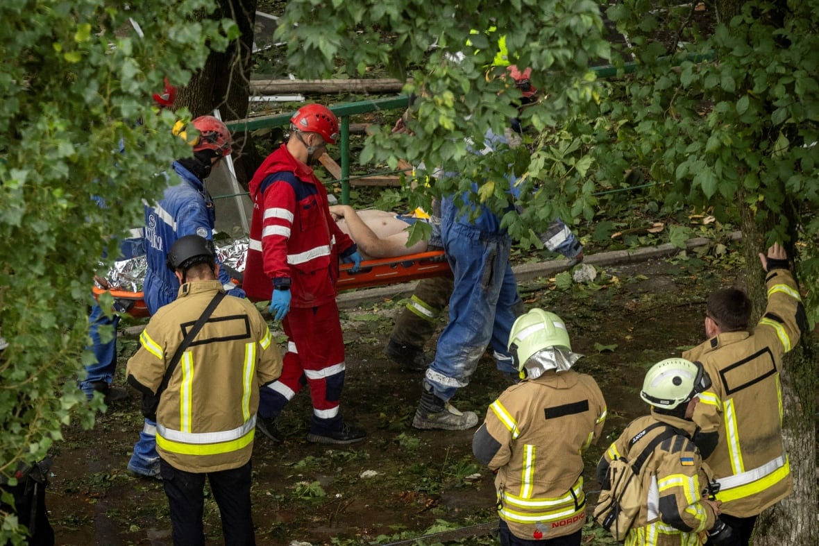 Emergency personnel carry an injured man.