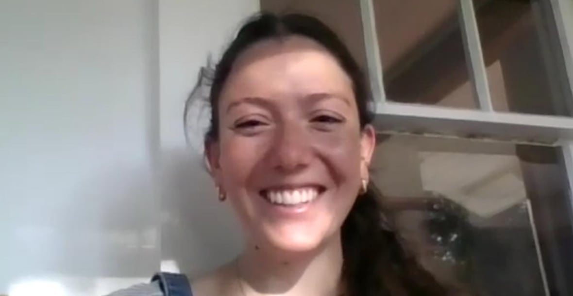 A Zoom screenshot of a smiling woman with her hair in a ponytail