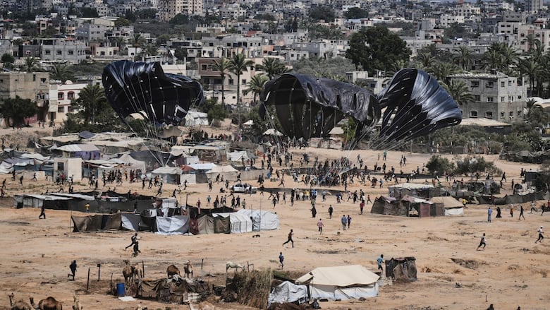 Palestinians rush to collect humanitarian aid airdropped into Zawaida in central Gaza Strip, Thursday, July 31, 2025.