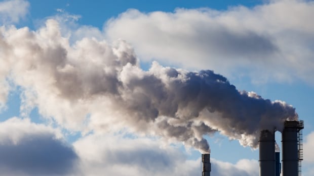 Emissions coming out of a factory smokestack