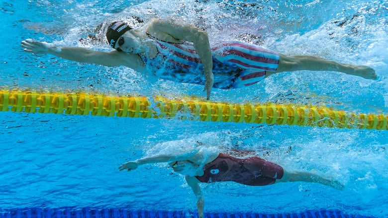 Two swimmers compete in the freestyle.