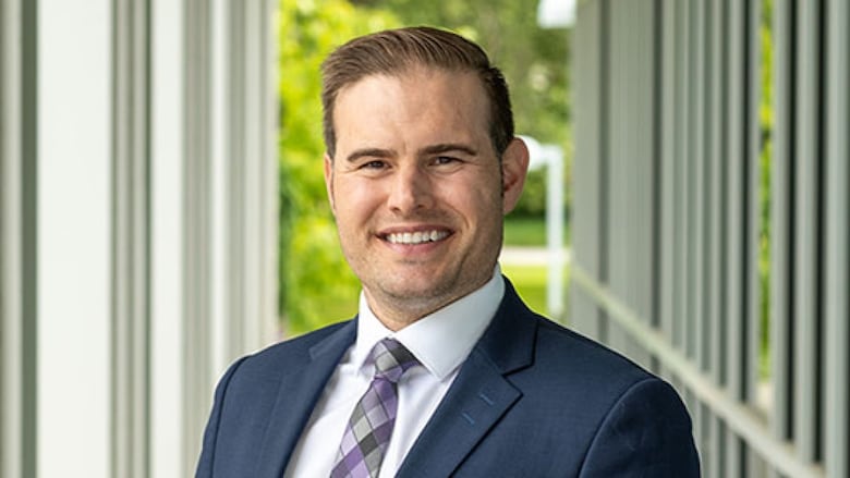 A portrait shot of a smiling middle-aged white male wearing a suit and tie.