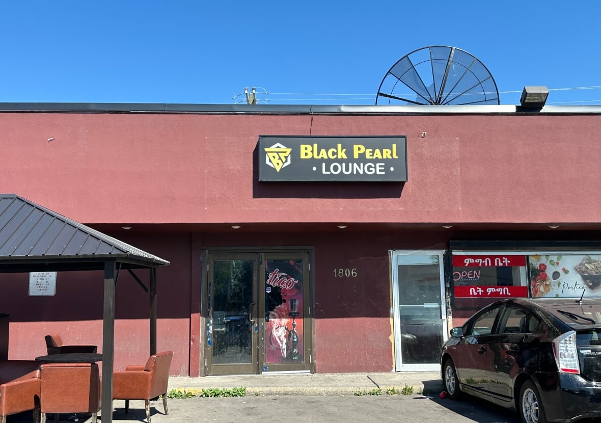 The front of a building in a strip mall. The sign says Black Pearl.