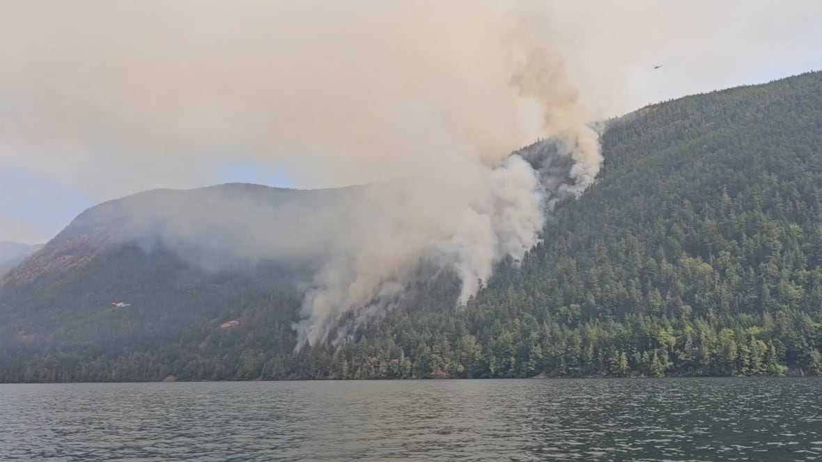 Smoke rises from the Wesley Ridge wildfire on the north side of Cameron Lake on July 31, 2025.
