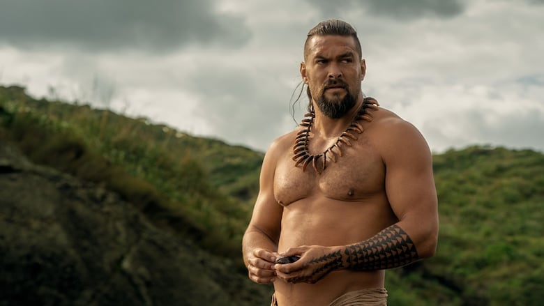 A shirtless man looks off into the distance.