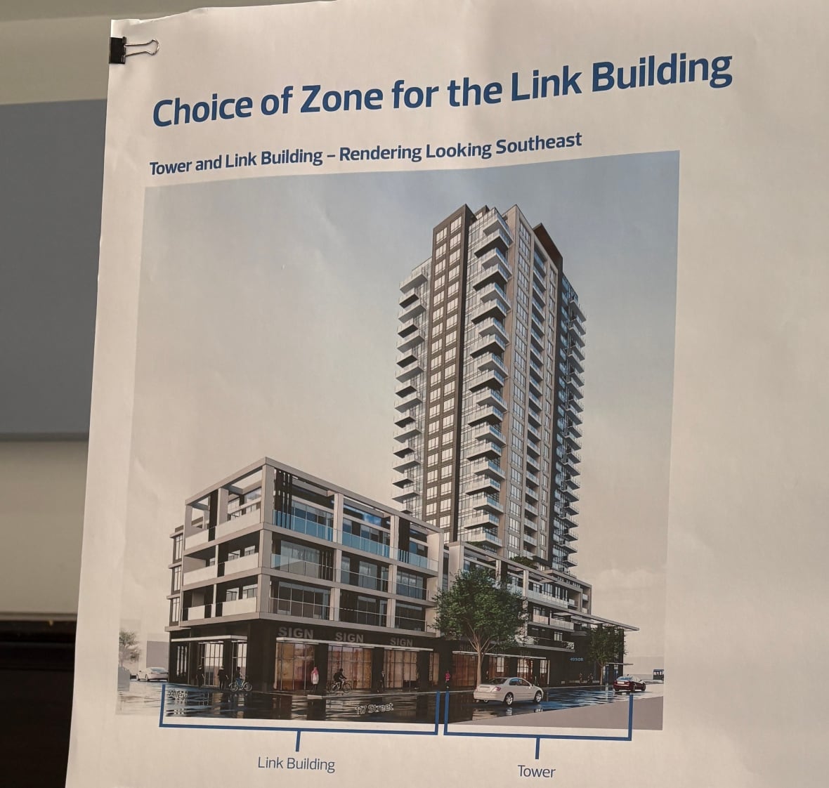 A board showing a photo of a realistic conceptual rendering of a residential tower.