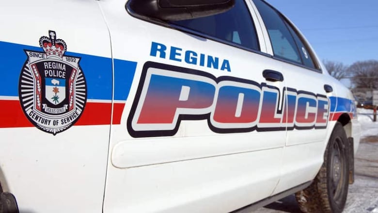 A white Regina police car with red and blue lettering on it.