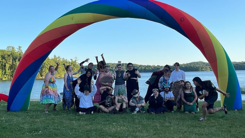 Campers pose under a rainbow arch at Rainbow Camp, a sleepaway camp for LGBTQ+ youth in Thessalon, Ont. 