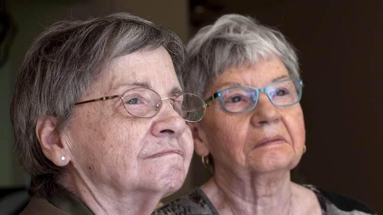 Two women look off into the distance.