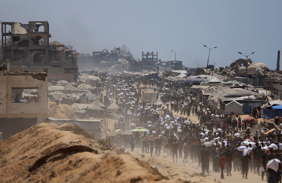 Palestinians carry aid supplies through a route.