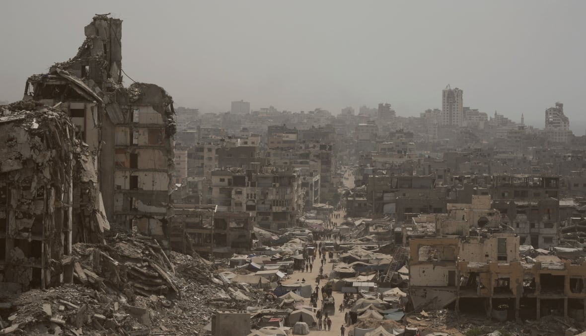 La foto tomada de los Tallers muestra que la gente camina por una calle corrupta de la ciudad, con ruinas de edificios de alto nivel a ambos lados de la tierra. Las montañas de los escombros y el horizonte destruidos en la distancia son el horizonte.