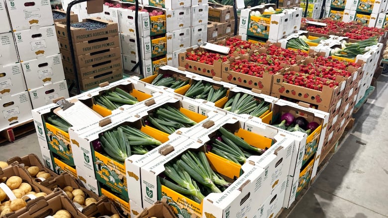 Stacks of bushels and boxes of fresh produce at a live produce auction.