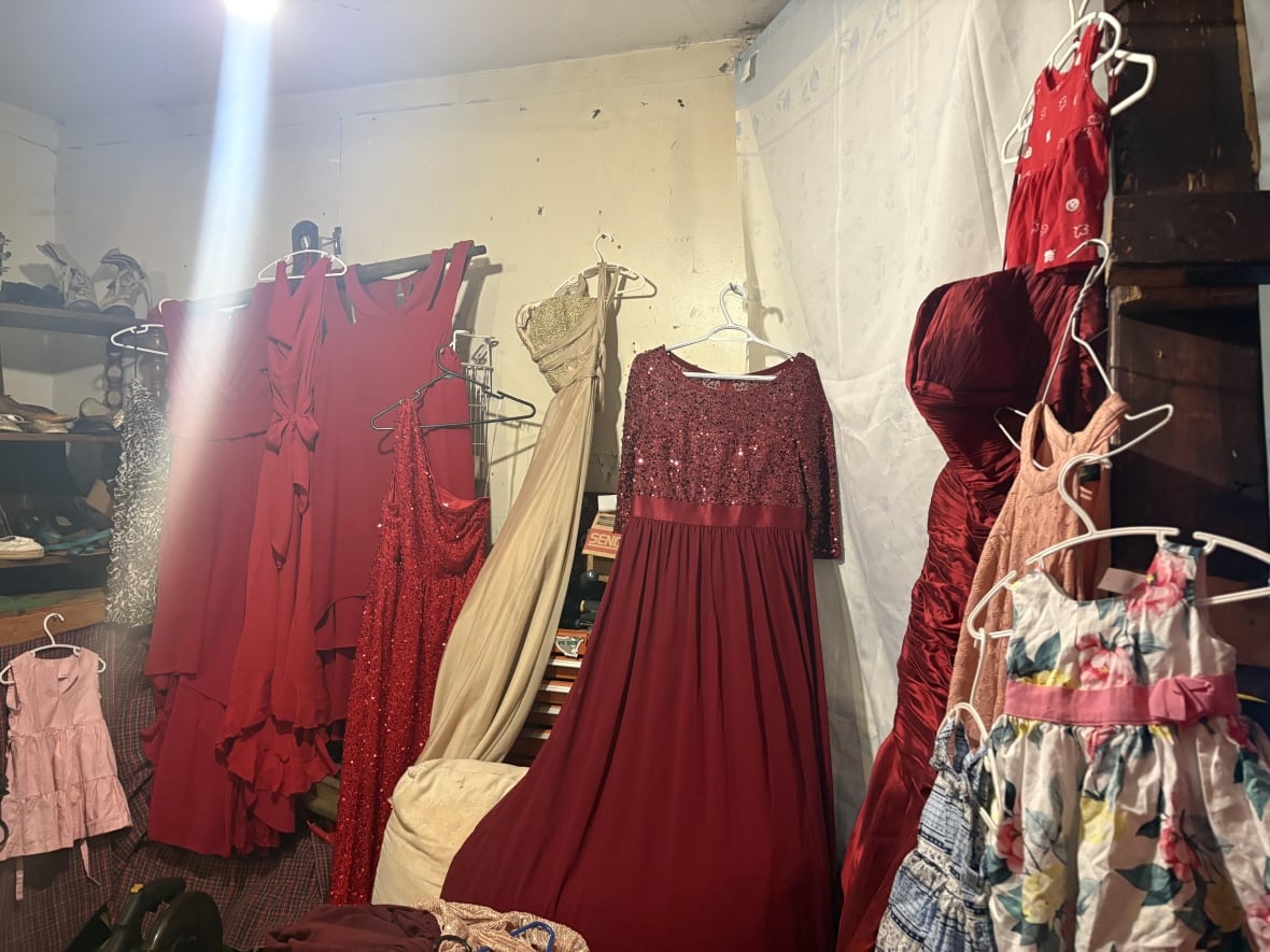 Red prom dresses are hung in the walls of a shed