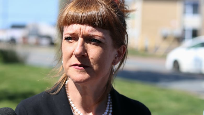 A woman looks off to the side with sunlight hitting her face.