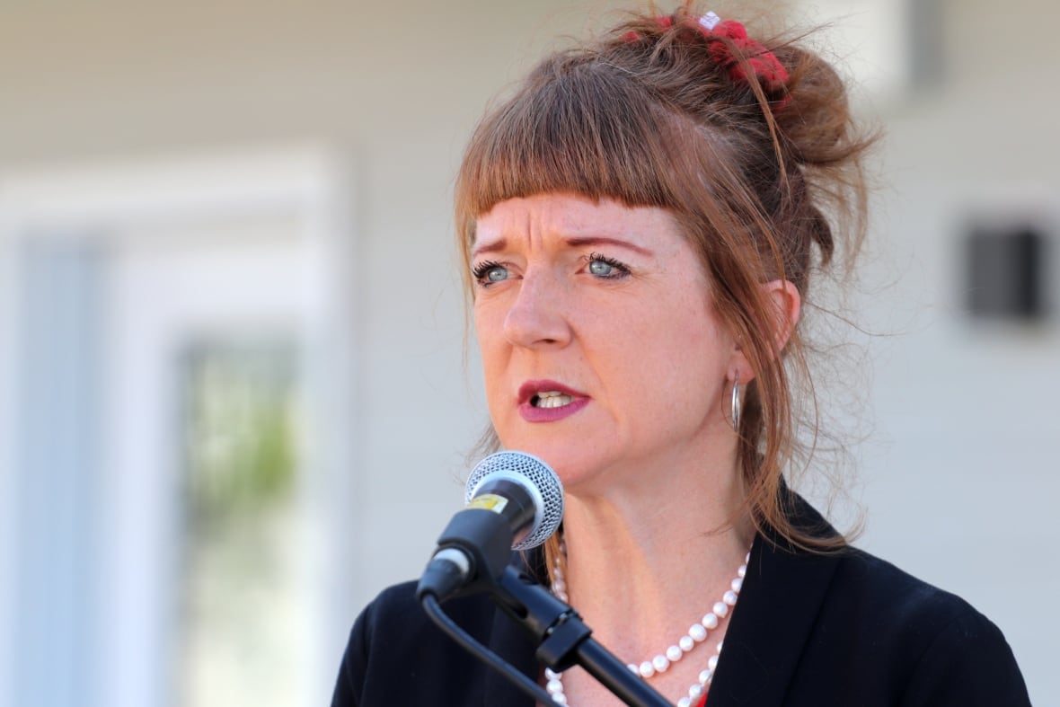 A woman speaking in front of a microphone.