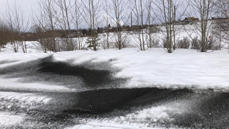 Black dust is visible on top of a snow bank 