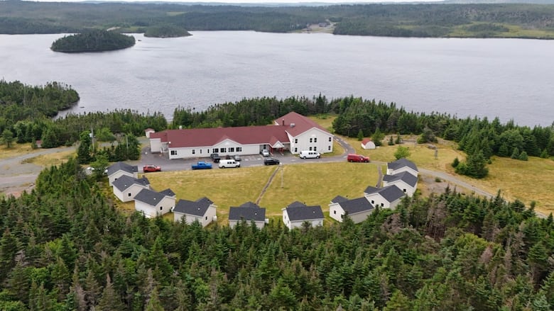 An aerial view of a large building and several smaller outbuildings.