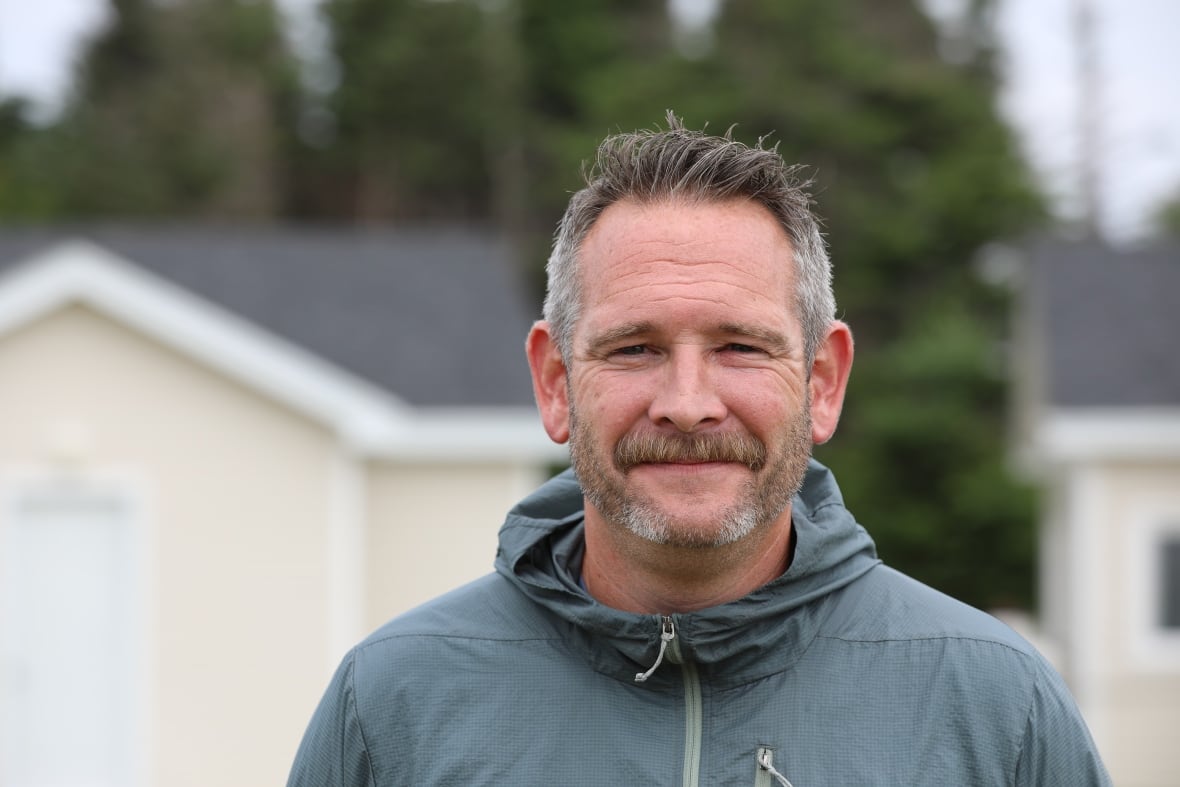 A man with greying hair and a beard.