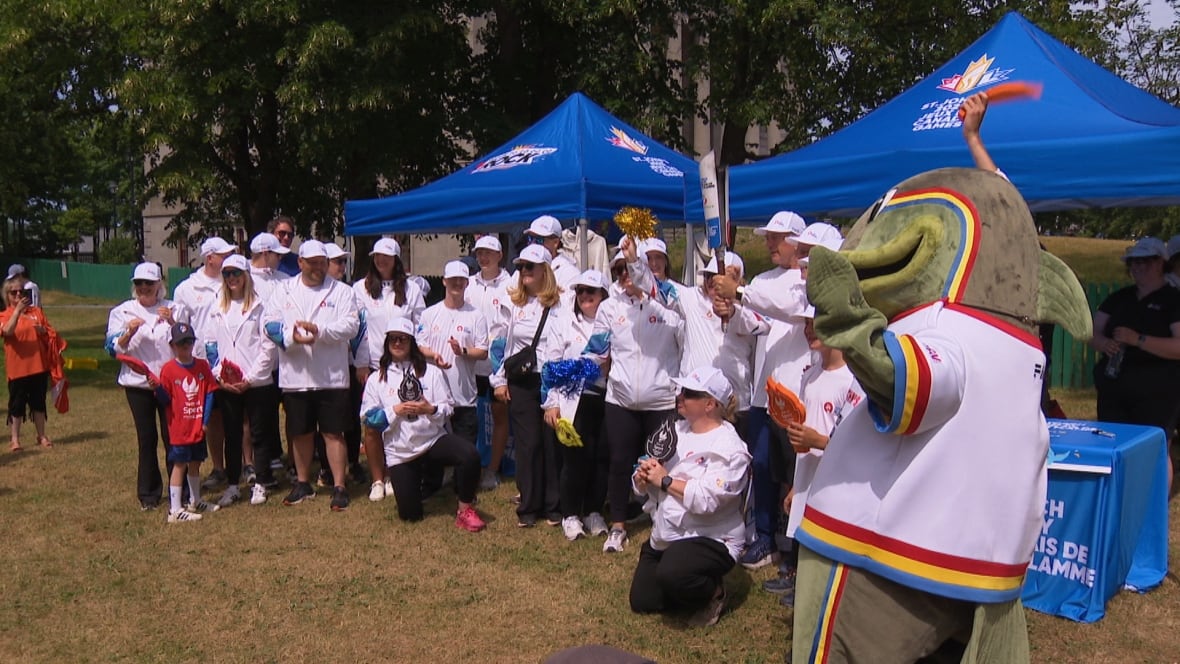 A group of people wearing white uniforms pose for a photo.