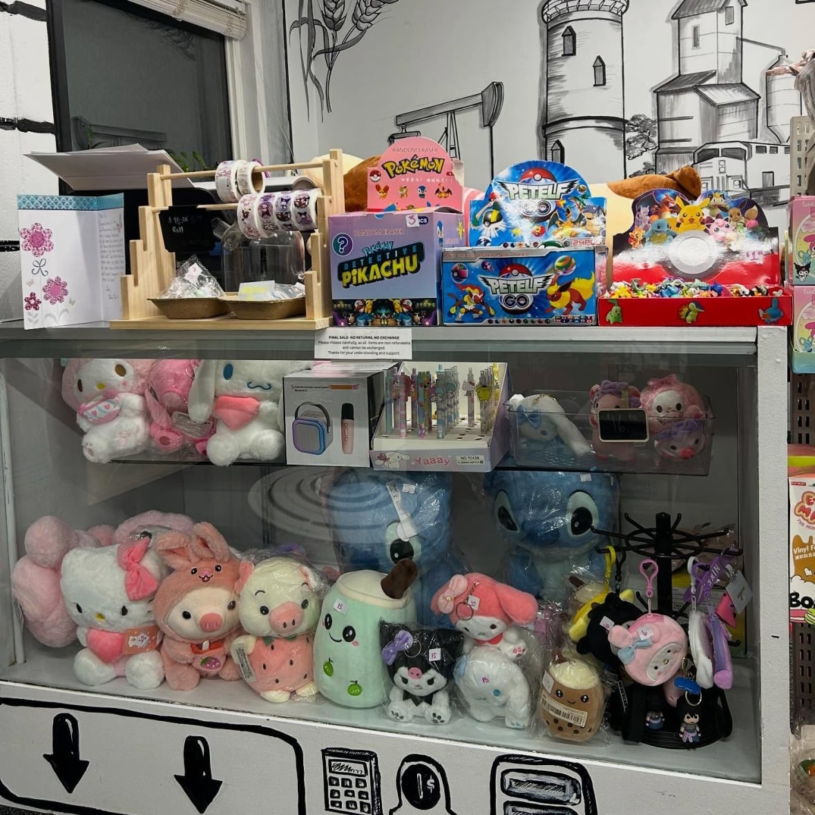 Plush figure items against a cartoon drawn wall.