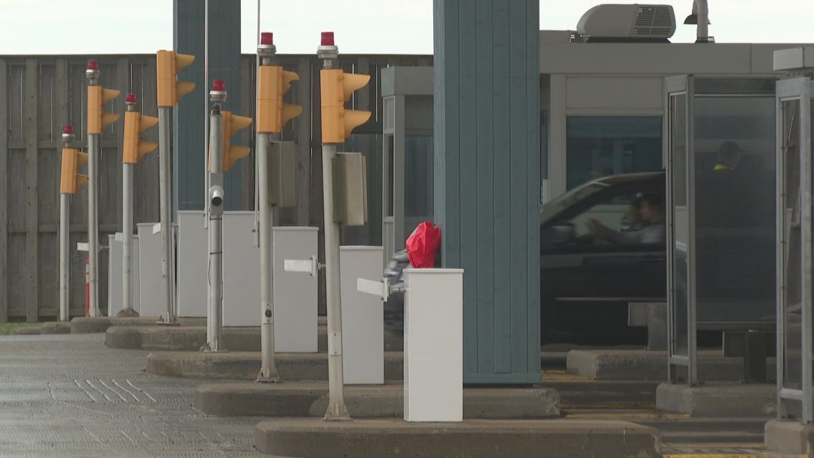 A car drives through a toll booth.